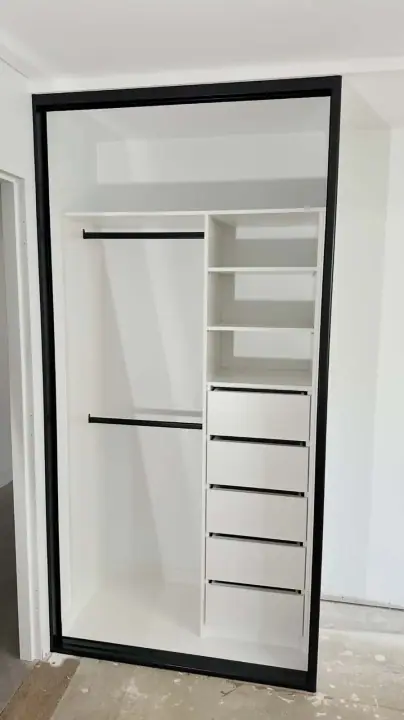 Black-framed sliding wardrobe internals fitted, floor still to come