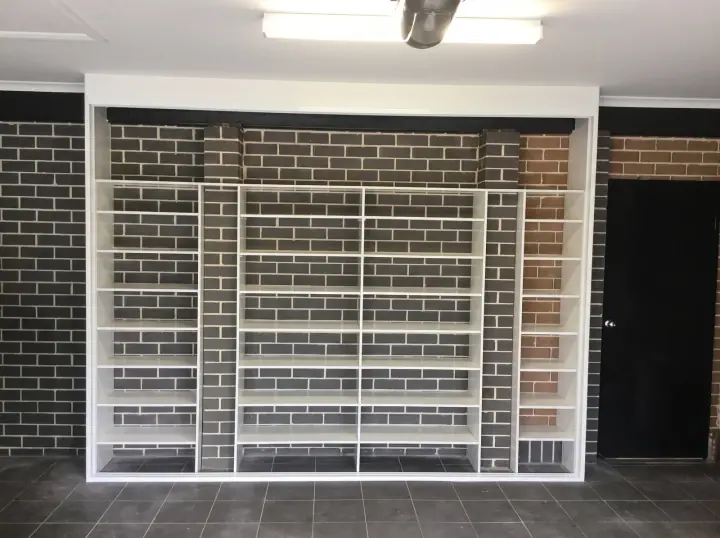 Garage shoe shelving fitted between brick walls