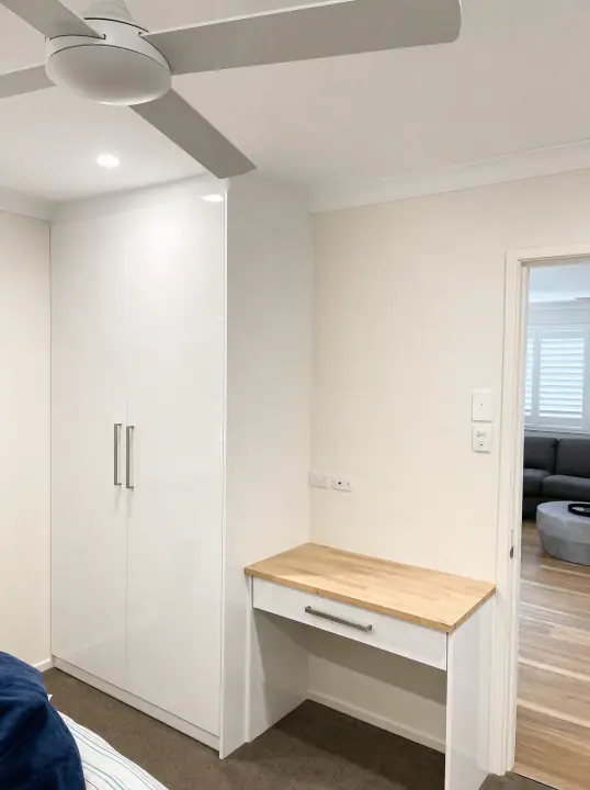 Study with timber desk and white gloss cupboards