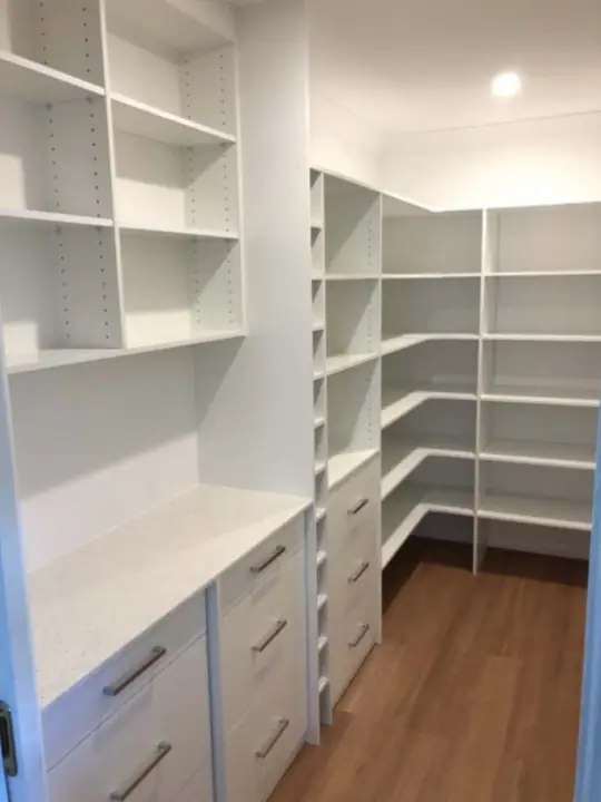 Study with a long desk, drawer towers and shelving on three walls