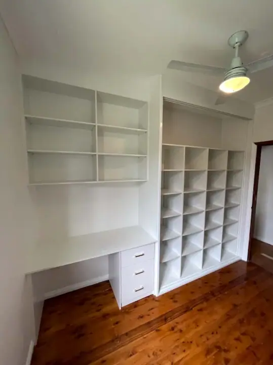 Desk with drawers and a wall of pigeon-hole shelving
