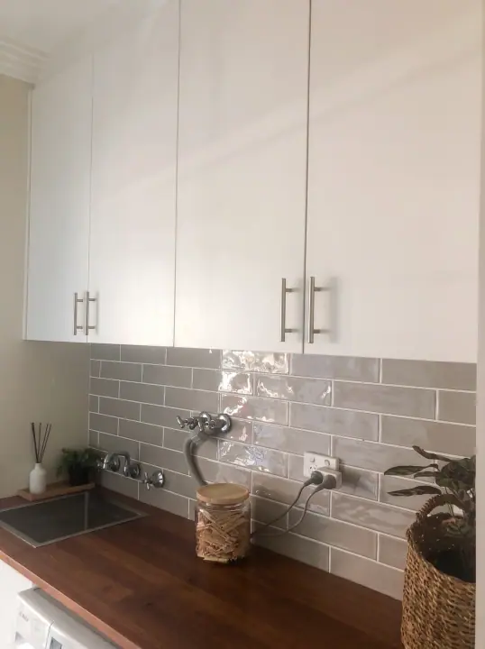 Laundry overhead cupboards and timber bench beside the washer