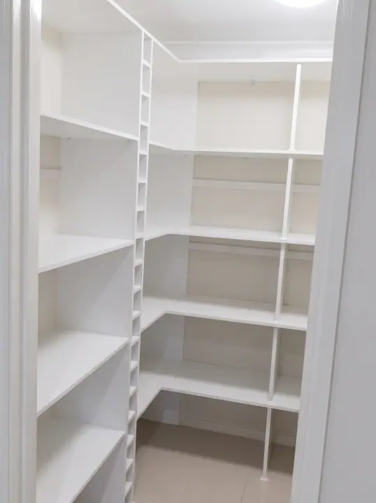 Walk-in pantry with adjustable shelving on three walls