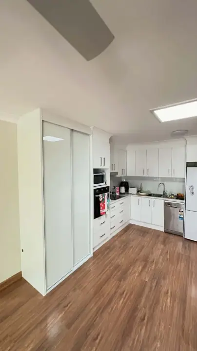 White glass sliding doors on a pantry beside the kitchen