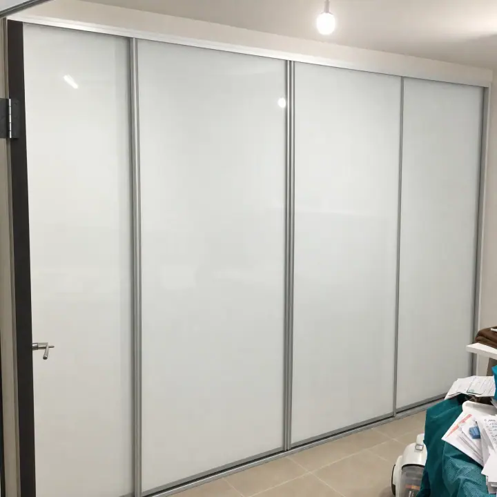 Floor-to-ceiling white glass sliding doors across a full bedroom wall