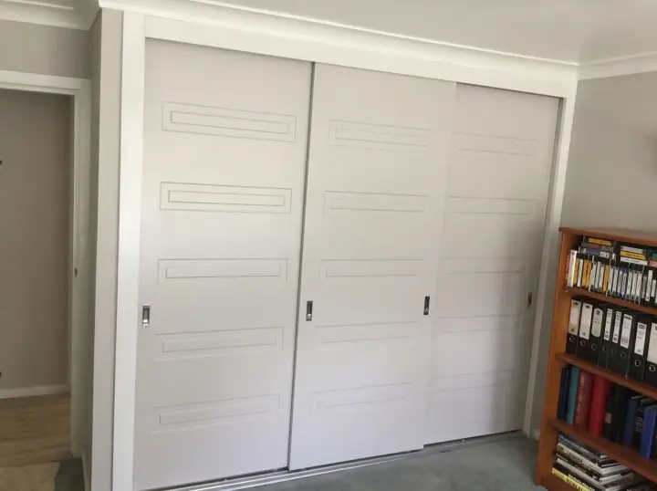 Routed shaker-style white sliding doors with a classic profile