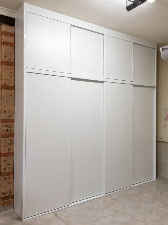 White panel sliding doors with overhead cupboards to the ceiling