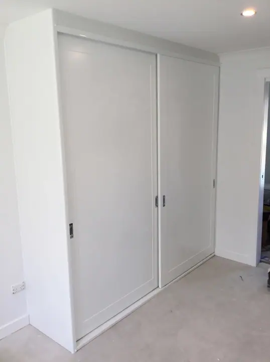 Three white poly panel sliding doors, floor to ceiling