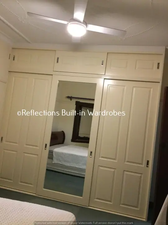 Cream four-door wardrobe with a central mirror panel