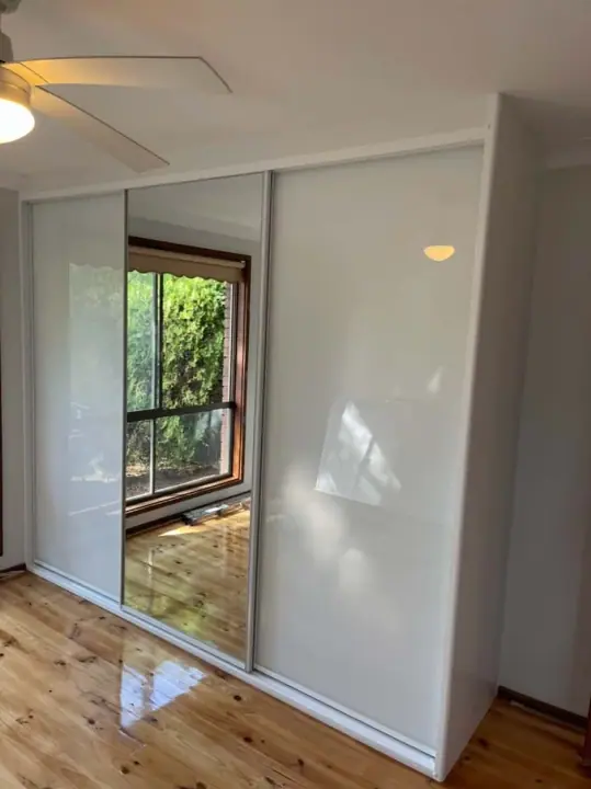 White glass sliding doors reflecting a garden window