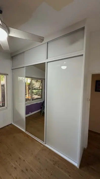 White glass and mirror sliding doors under overhead cupboards