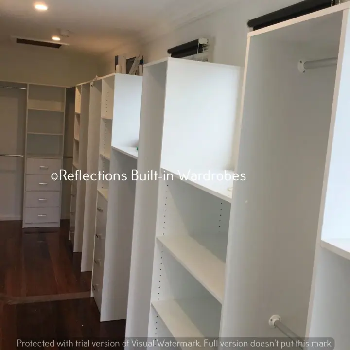 Long walk-in wardrobe with shelving and hanging on both sides
