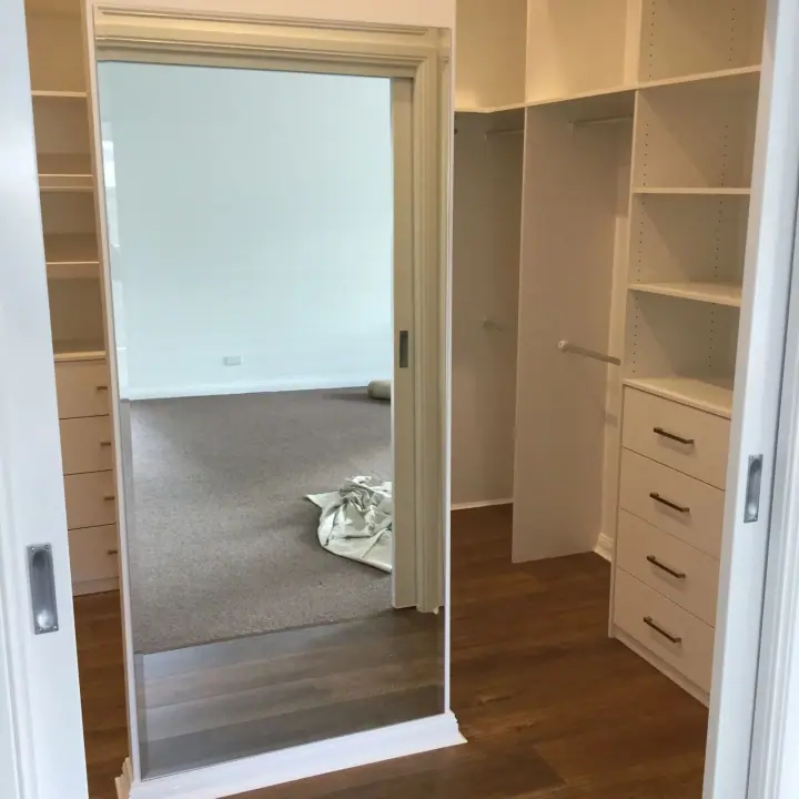 Walk-in wardrobe seen through the bedroom doorway