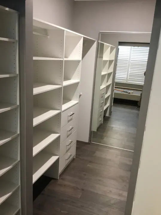 Walk-in wardrobe shelving beside a bedroom window