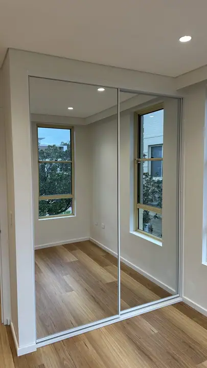 Mirrored sliding doors beside a sunny window