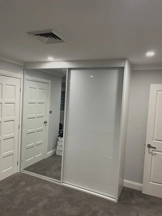 White glass sliding wardrobe in a hallway