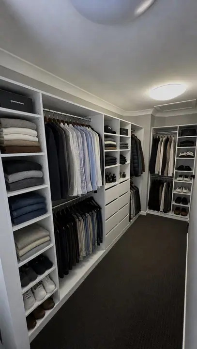 Walk-in wardrobe fitted with suits, shirts and drawers