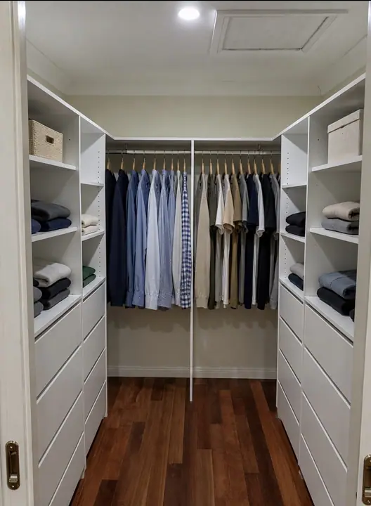 Wide walk-in wardrobe with hanging shirts and open shelving