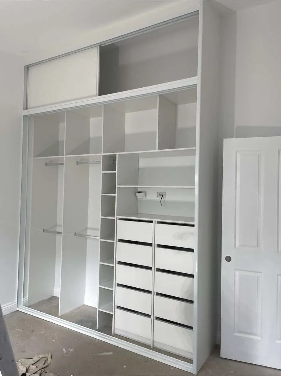 Installer fitting a custom wardrobe in a bedroom