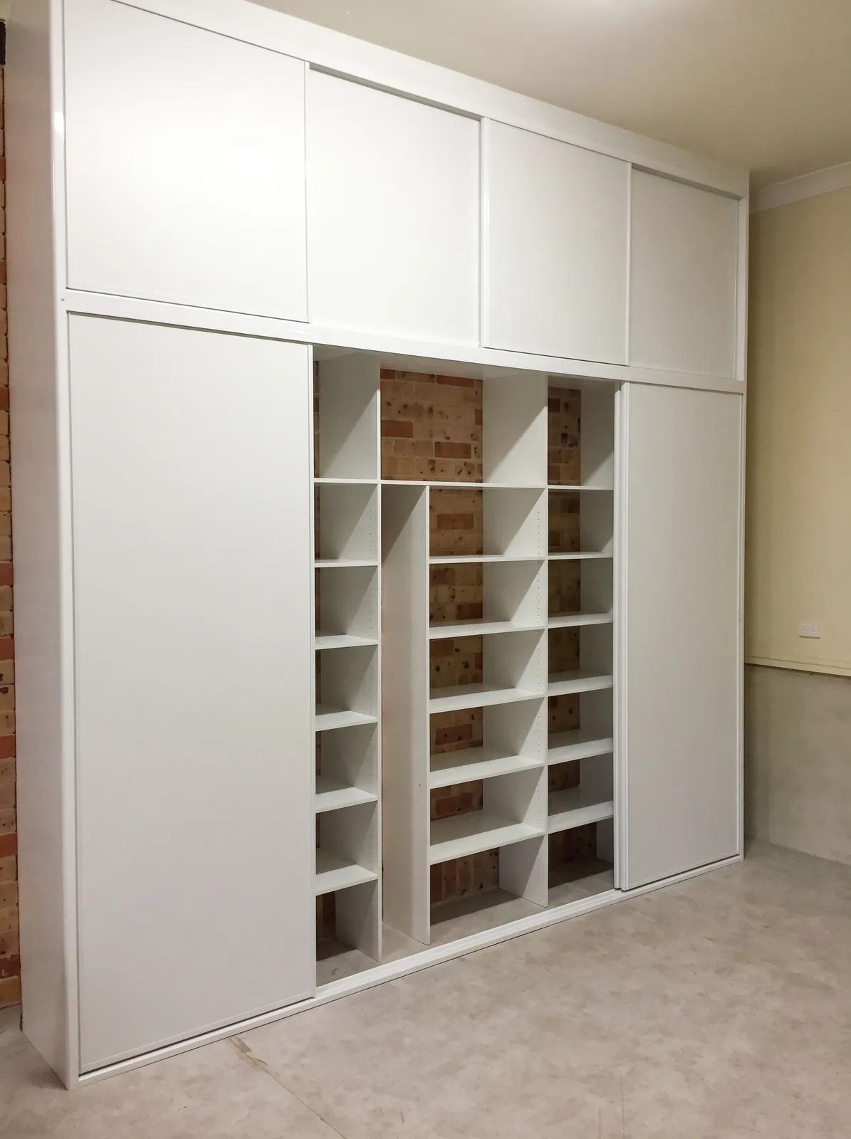 Garage storage wall with floor-to-ceiling cupboards and open shelving
