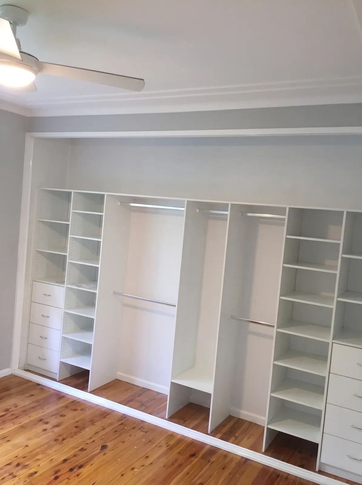 Wardrobe interior with LED-lit shelving and a drawer bank