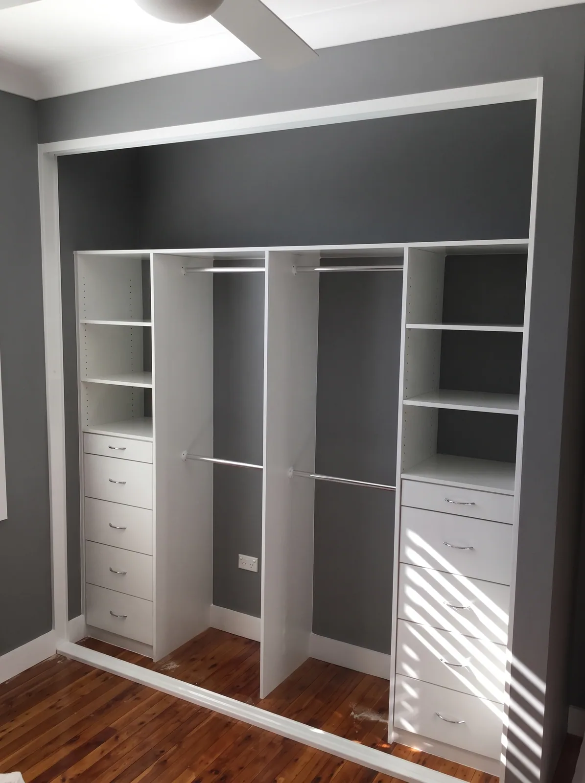 Built-in wardrobe with overhead cupboards reaching the ceiling