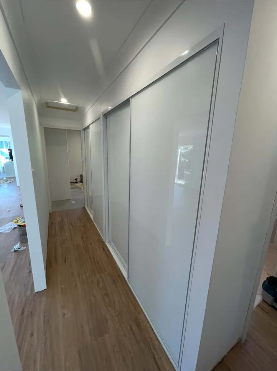 Full-wall sliding wardrobe in a compact granny flat bedroom